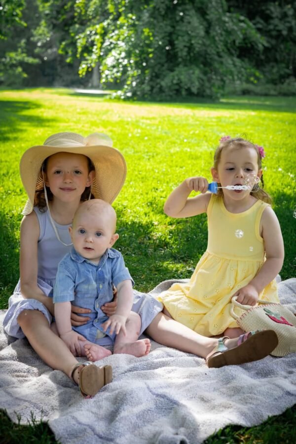 Two children in sun hats on a picnic blanket