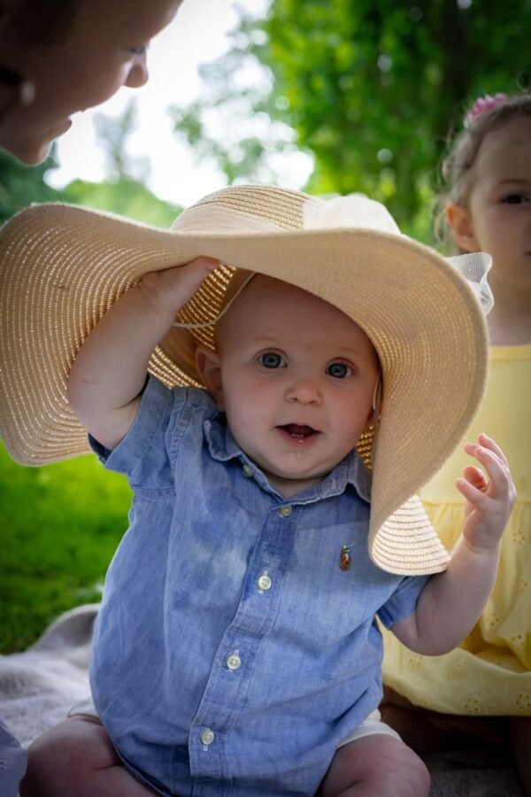 A little boy in a wide sun hat in the park