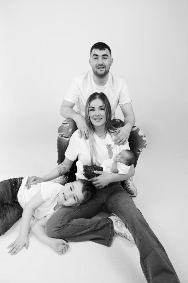 A father with his children and newborn, in black and white