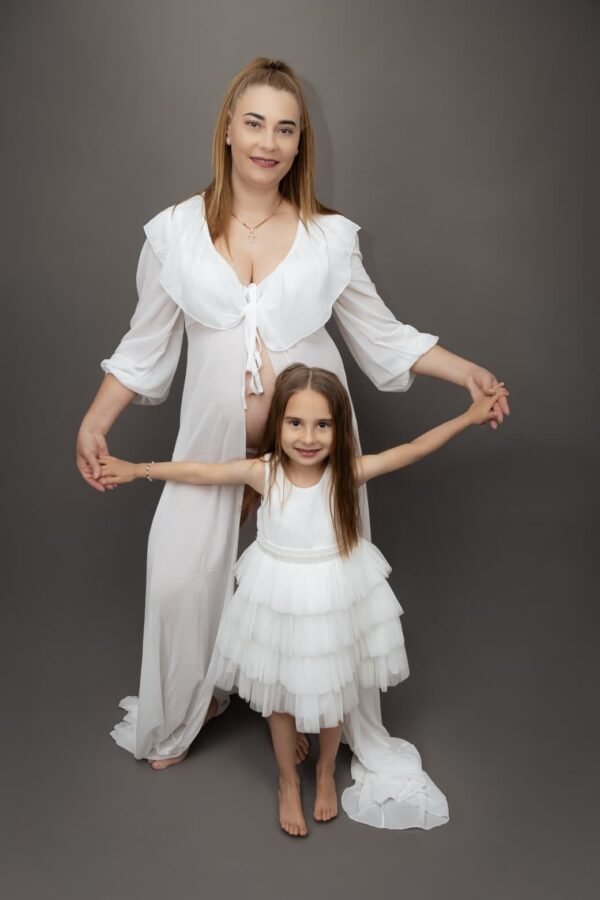 A mother and daughter in matching white dresses