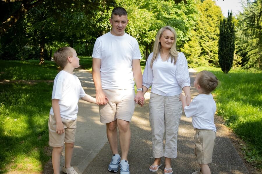 A family walking hand in hand along a park path