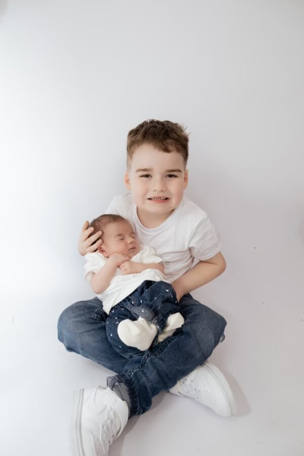A young boy holding his newborn sibling