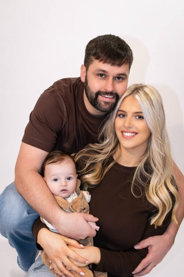 New parents cradling their newborn in the studio