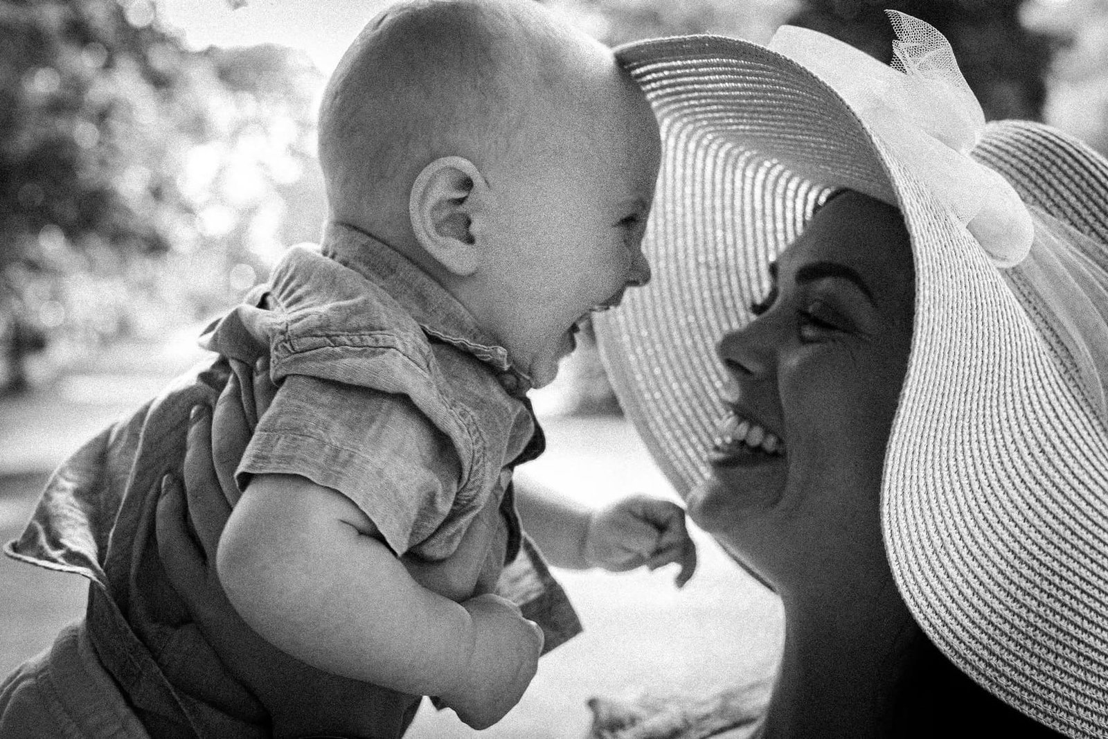 A mother and baby laughing together in soft light