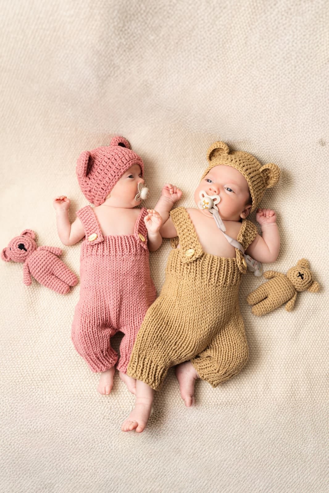 Two newborns in soft knitted outfits