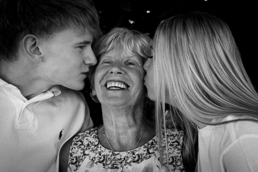 A mother laughing with her children, in black and white