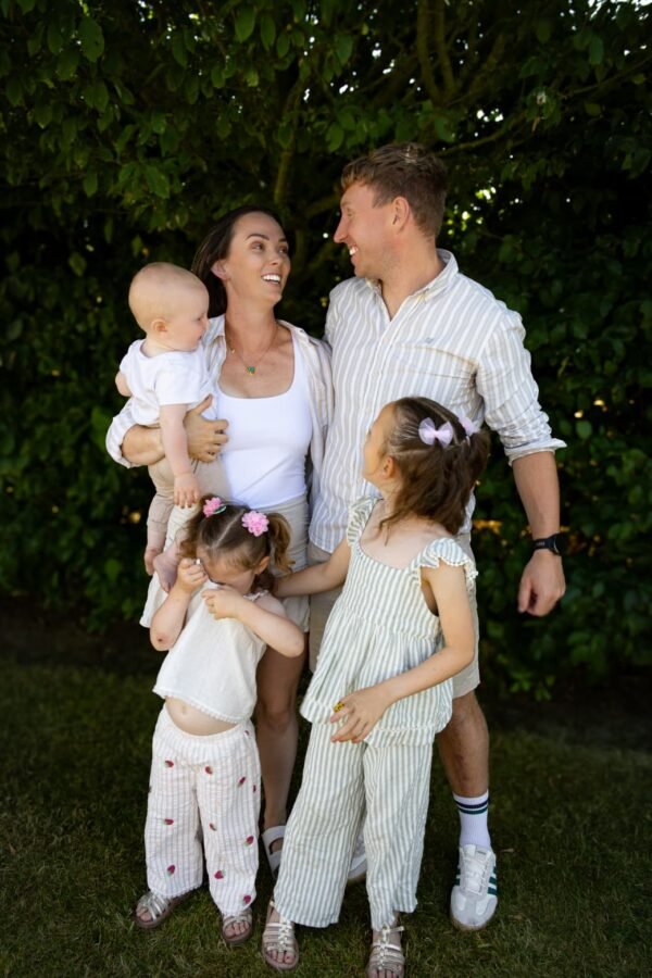 A family together outdoors, one child held close