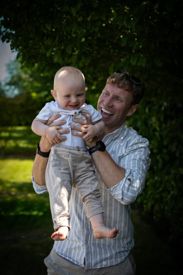 A father lifting his baby outdoors